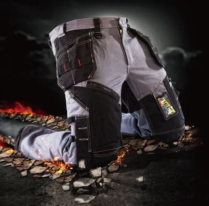 Blaklader workwear displayed on a dark background, showing close‑up details of work trousers and pockets with tools and debris on the ground, representing the jackets, sweatshirts, polos and trousers included in the Blaklader Workwear Sale.