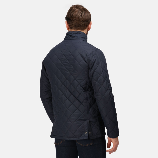 Man wearing a navy quilted jacket on a white background.
