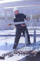 Man wearing Lyngsoe FOX3041 rain suit holding metal bar on construction site