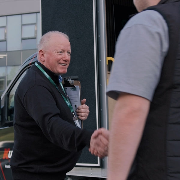 Solutions for All Business Sizes
Kustom Workwear team member greeting a customer at the door of the mobile fitting showroom during an on-site visit.