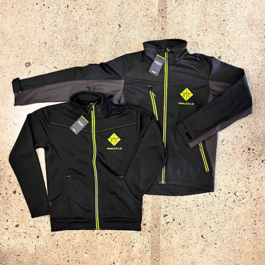 Black softshell jacket and matching hoodie with yellow zip detailing and embroidered company logo showing a coordinated branded workwear set.