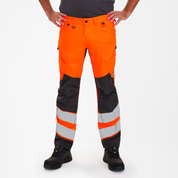 Safety pants worn by a model, showing reinforced knees, bright colour and reflective safety stripes.