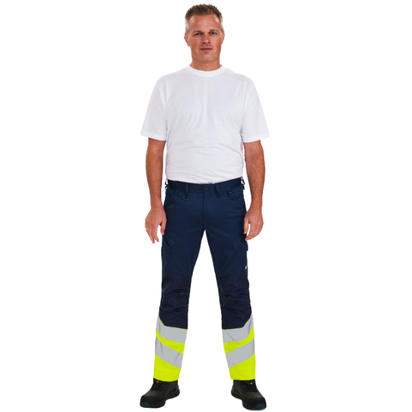 Person wearing navy work pants with reflective yellow and gray stripes on a white background. 