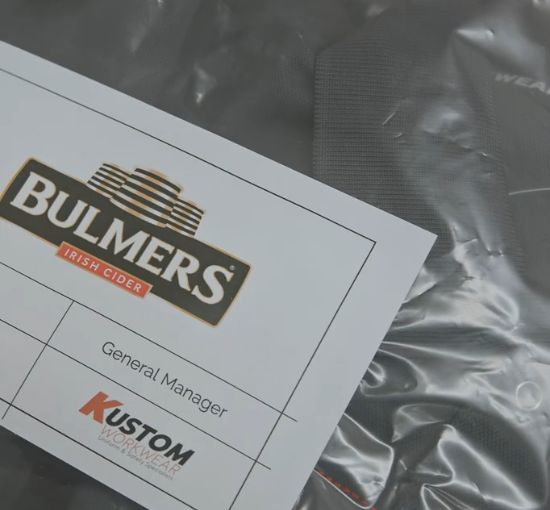 Individually labelled workwear man pack prepared by Kustom Workwear showing a personalised delivery label on a sealed garment bag.