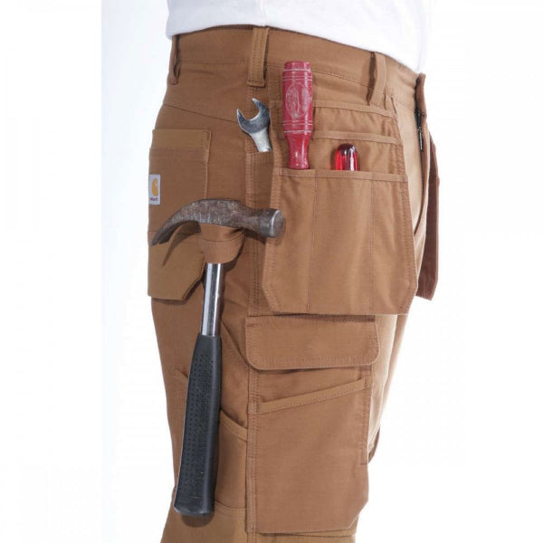 Close-up of brown work trousers showing tools held in the utility pockets